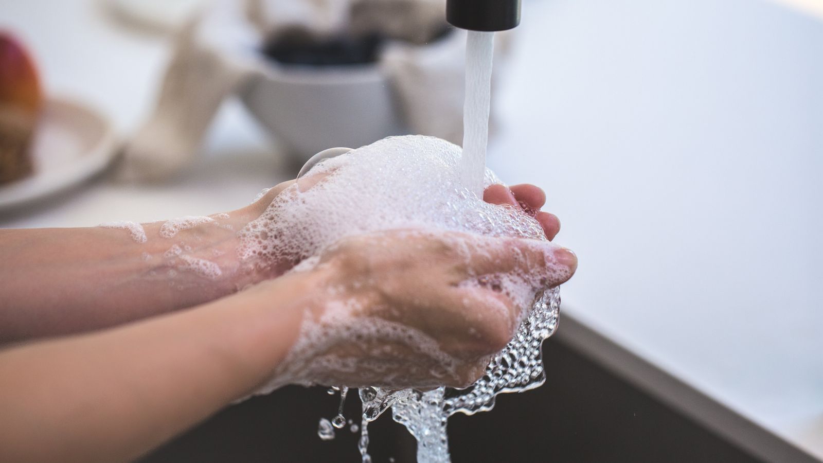 Hände werden am Waschbecken mit Seife gewaschen
