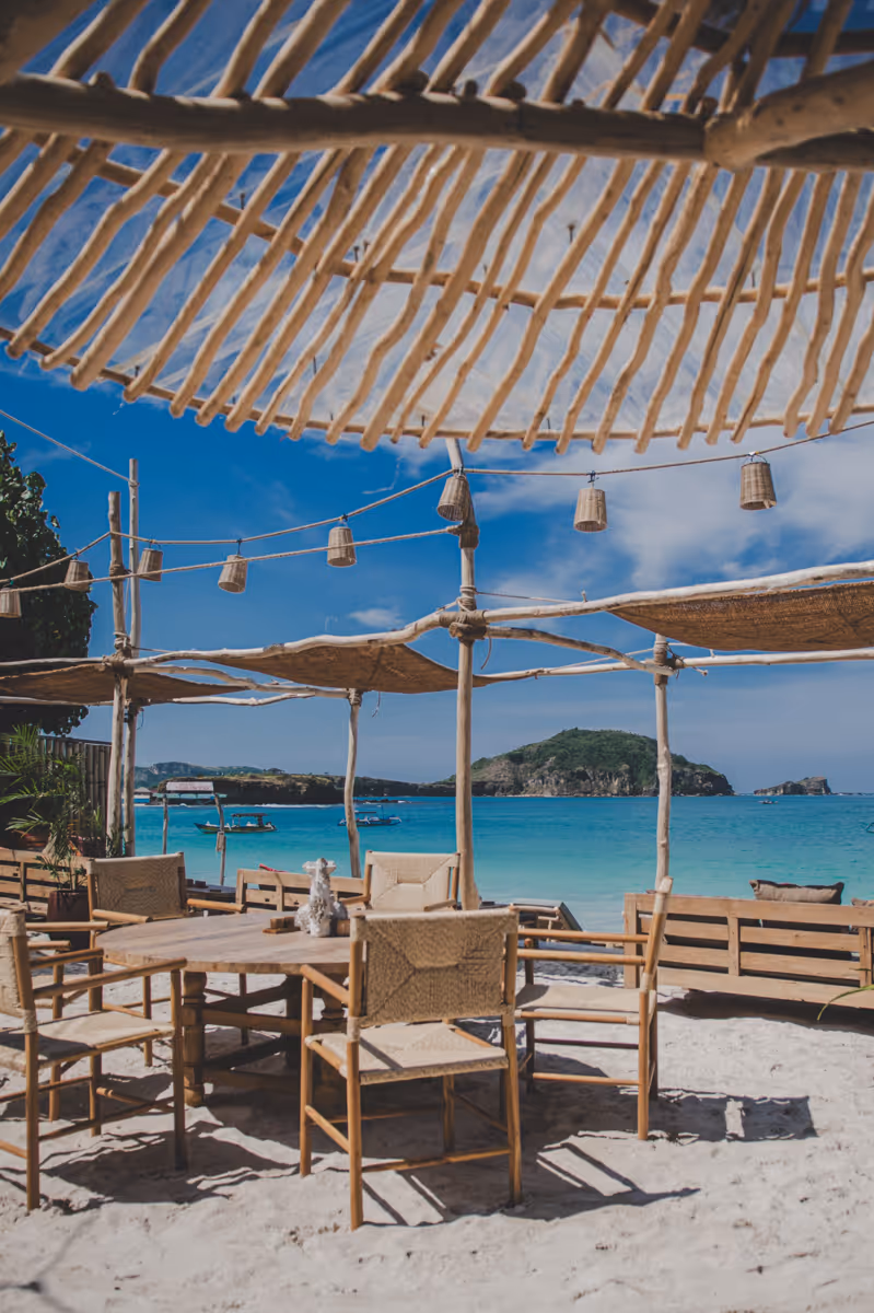 Beachfront table and bamboo shade with sea view.