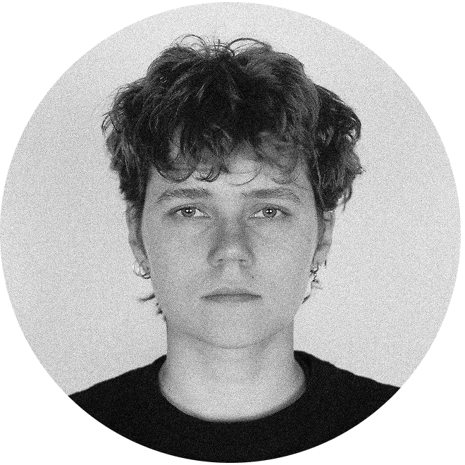 Black and white close-up portrait of a young person with curly hair wearing a black top, facing forward with a neutral expression.