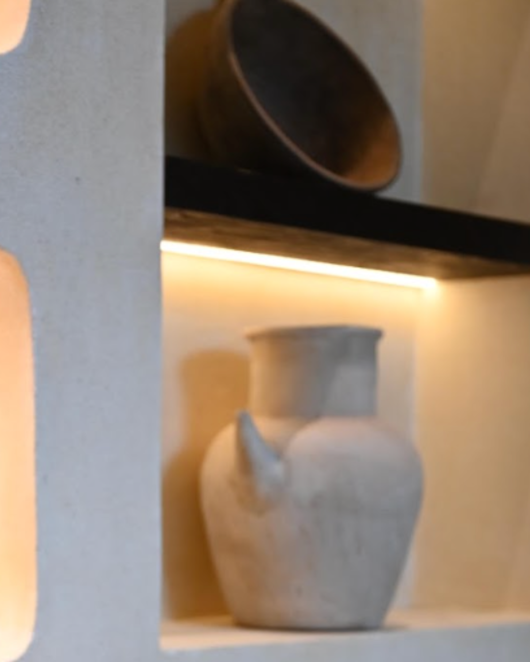 A clay urn in a softly lit plaster niche