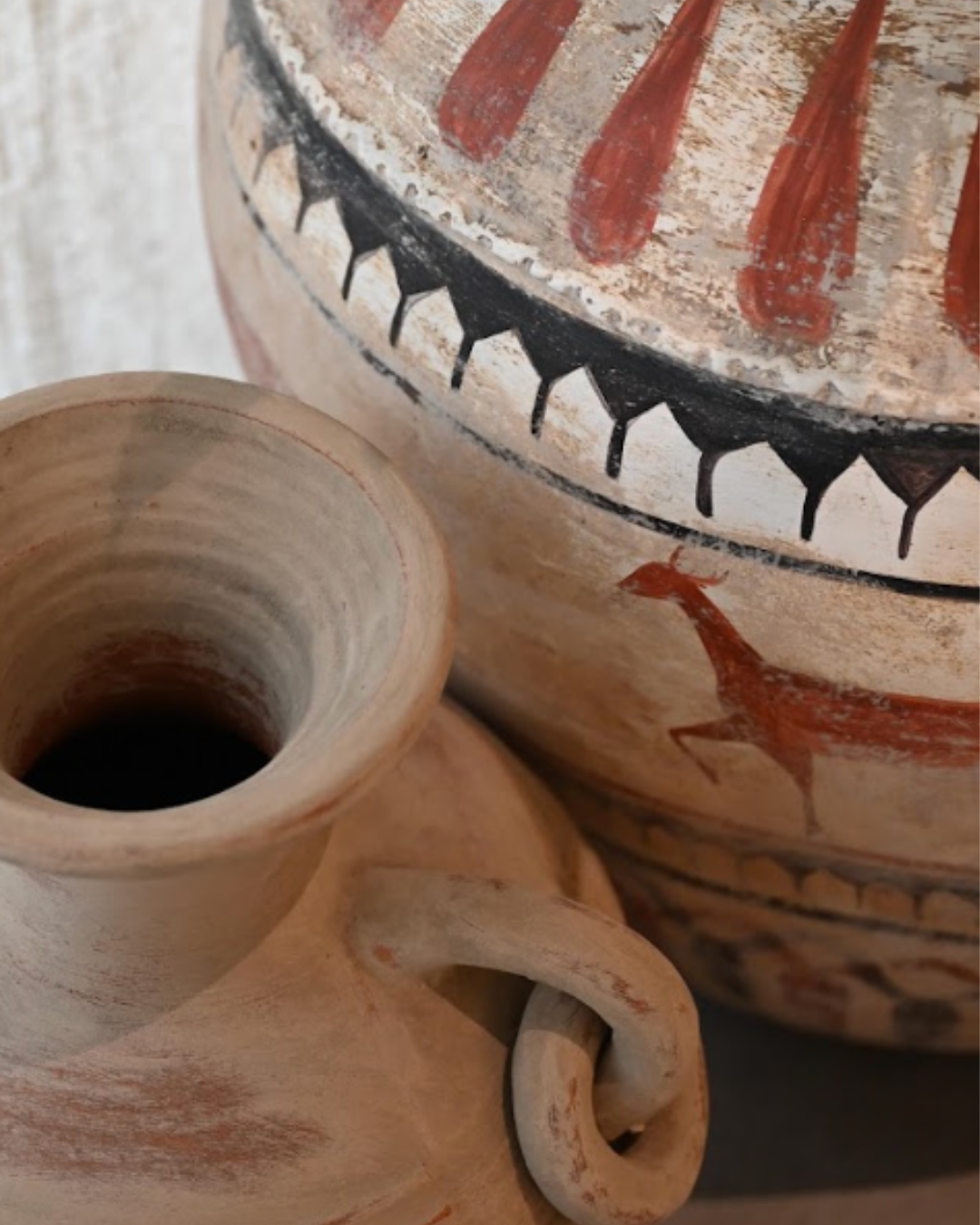Hand-painted terracotta pottery with red and black motifs