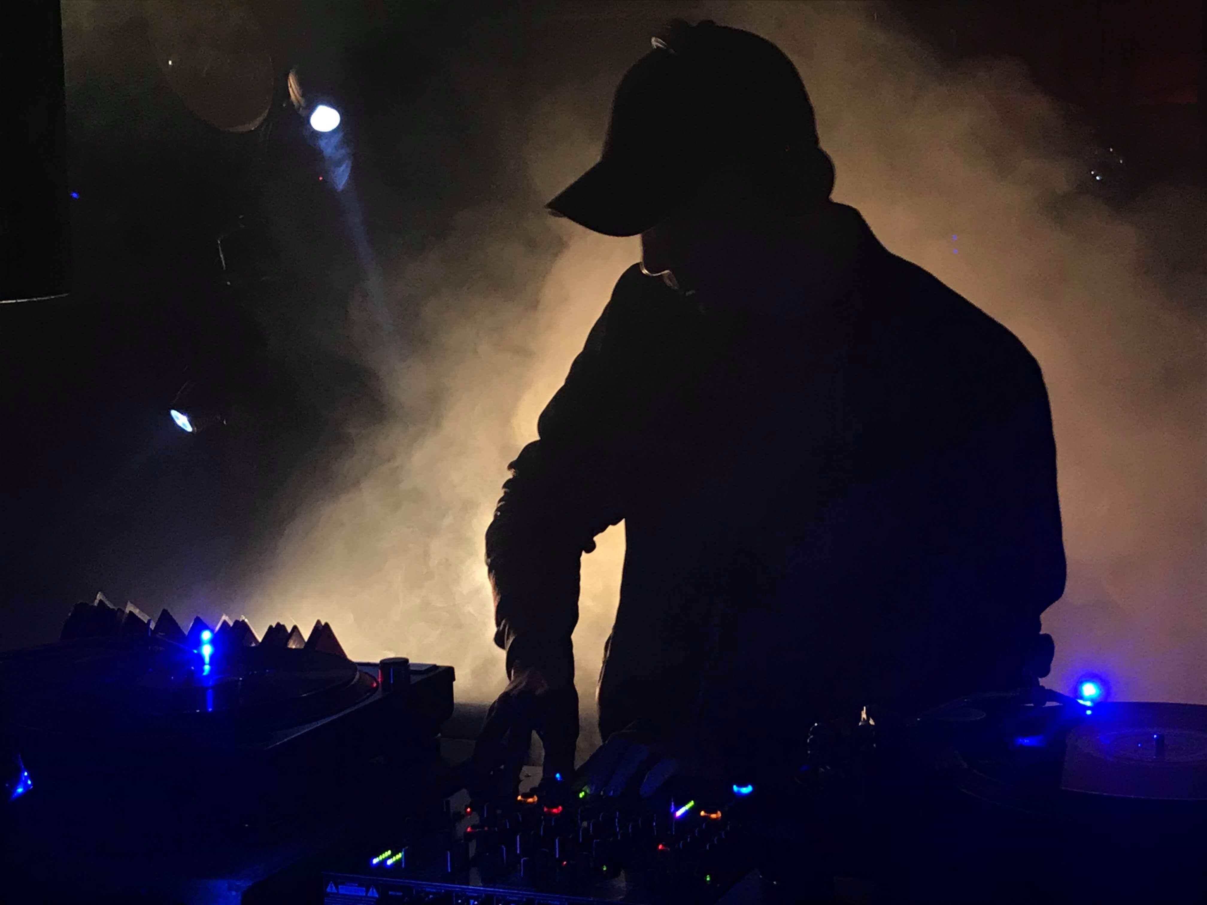 Timeless profile of a set in full flow—pure vinyl and raw presence, backlit by haze.