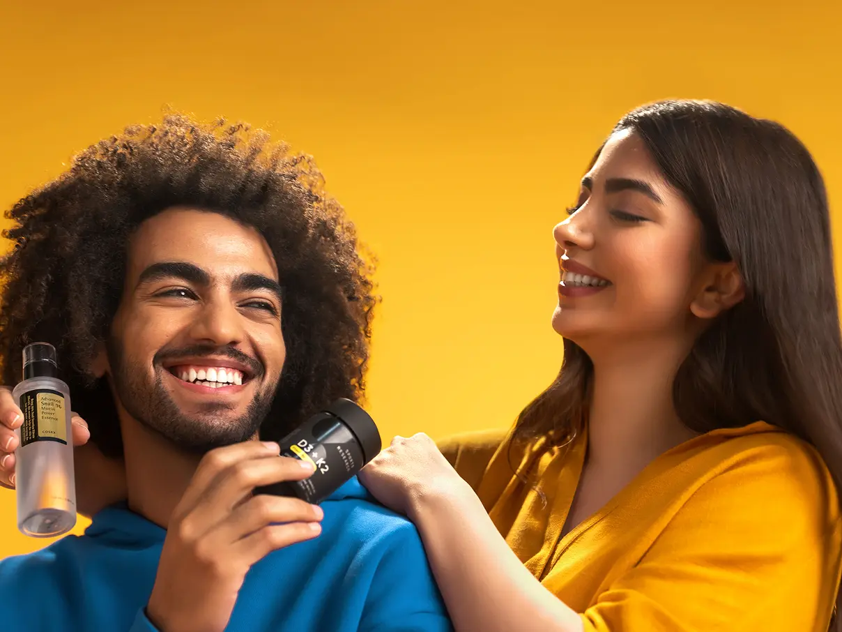 A man and a women smiling, each holding an iHerb product.