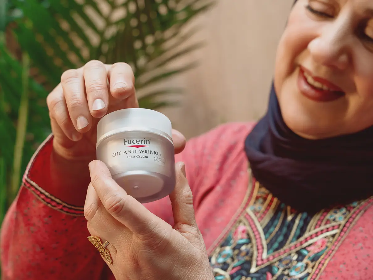 Elderly woman holding an iHerb product.