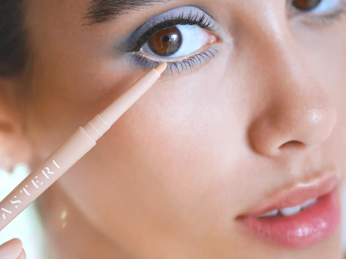 Female model applying Asteri mascara.