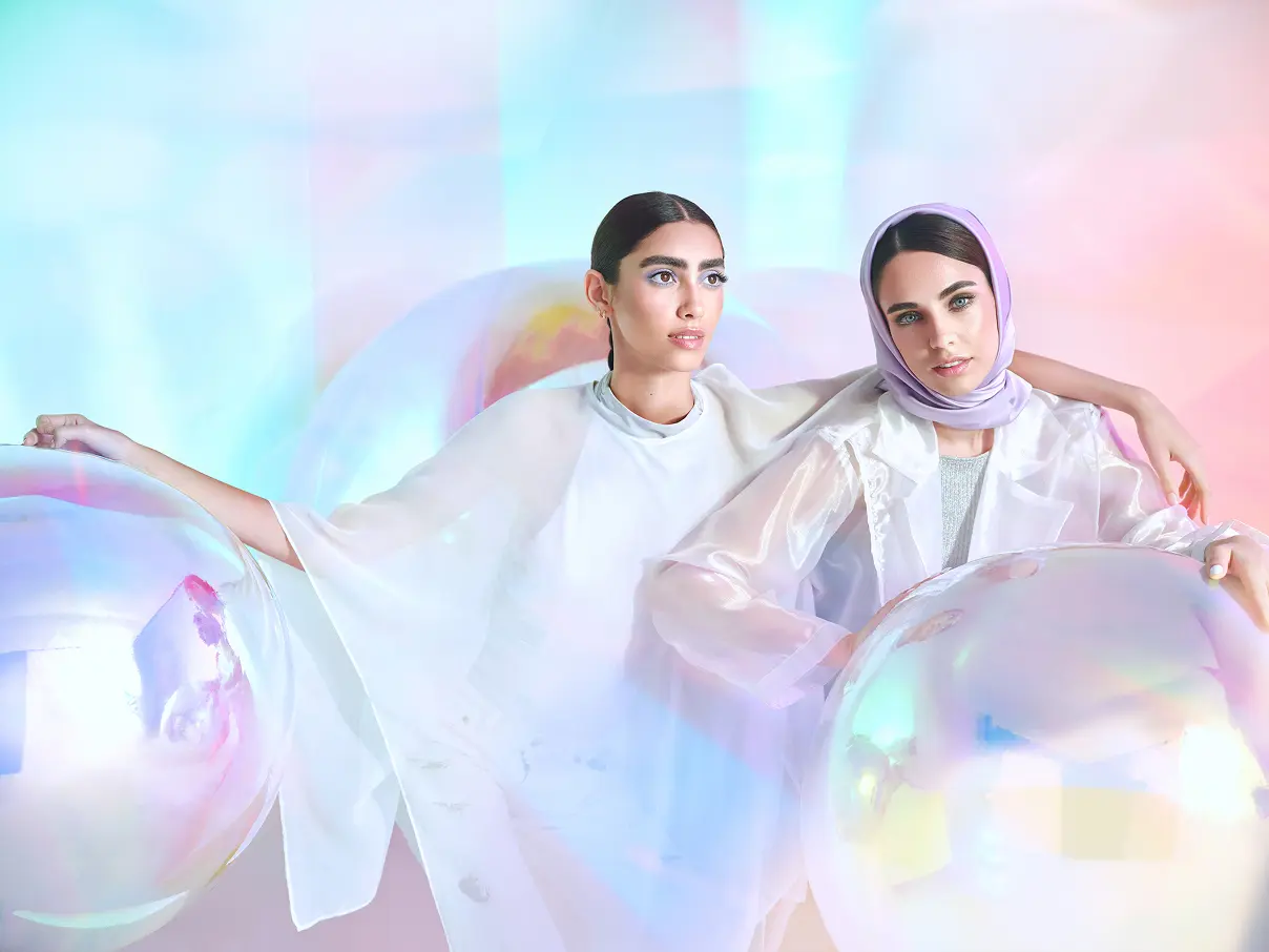 Two female models are sitting next to each other, wearing Asteri makeup.