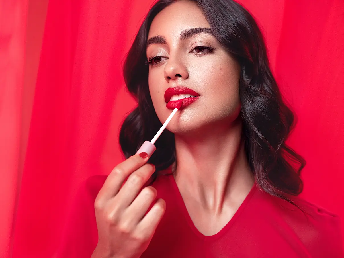 Female model applying Asteri lipstick.