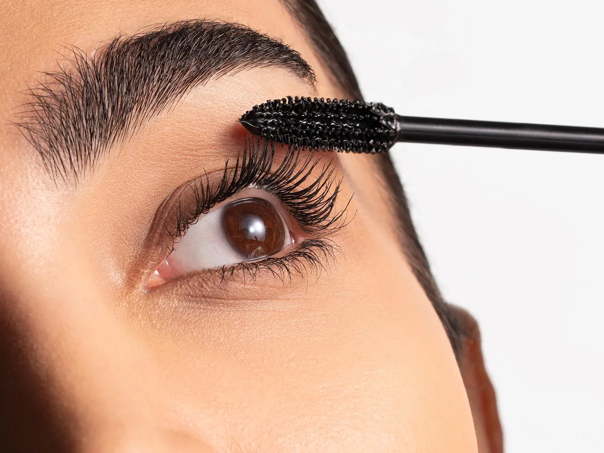 Close up of a woman applying mascara