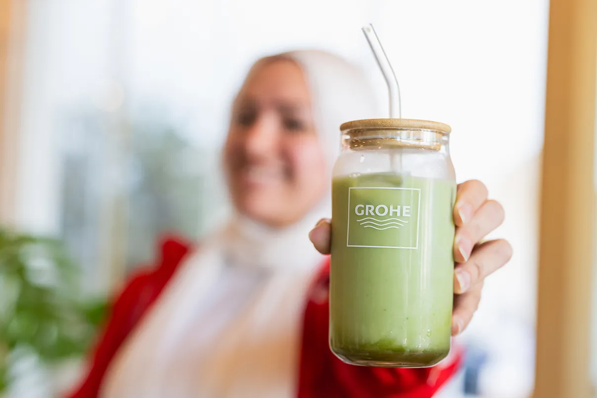 Woman holding a glass with GROHE logo