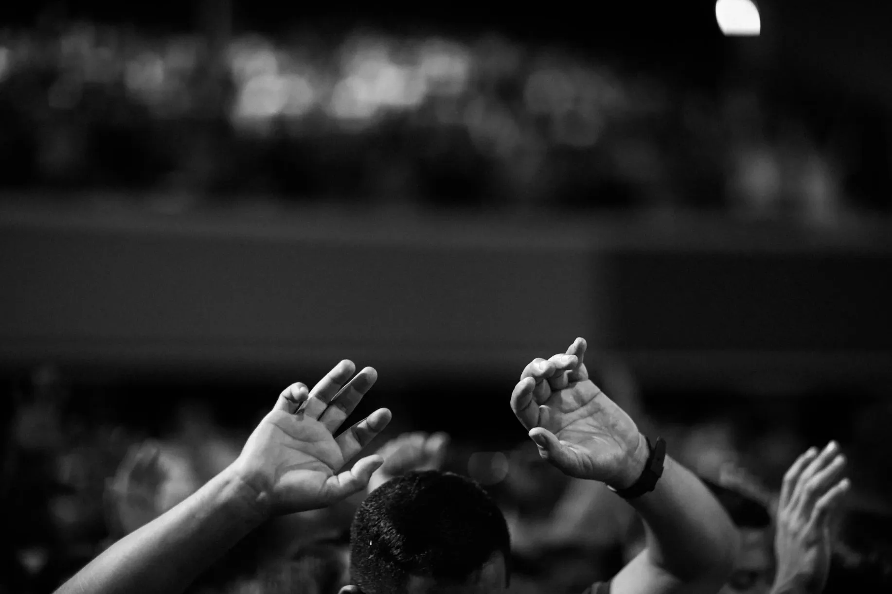 Black and white photo of hands raised in worship