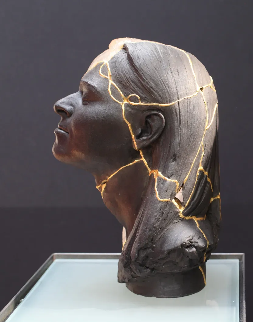 A black statue of a woman with gold veining