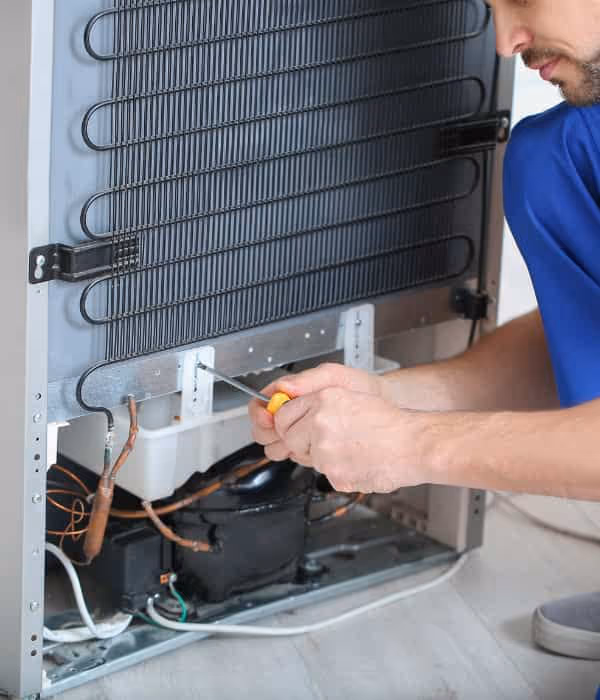 Technician diagnosting and repairing a refrigerator in Clairemont