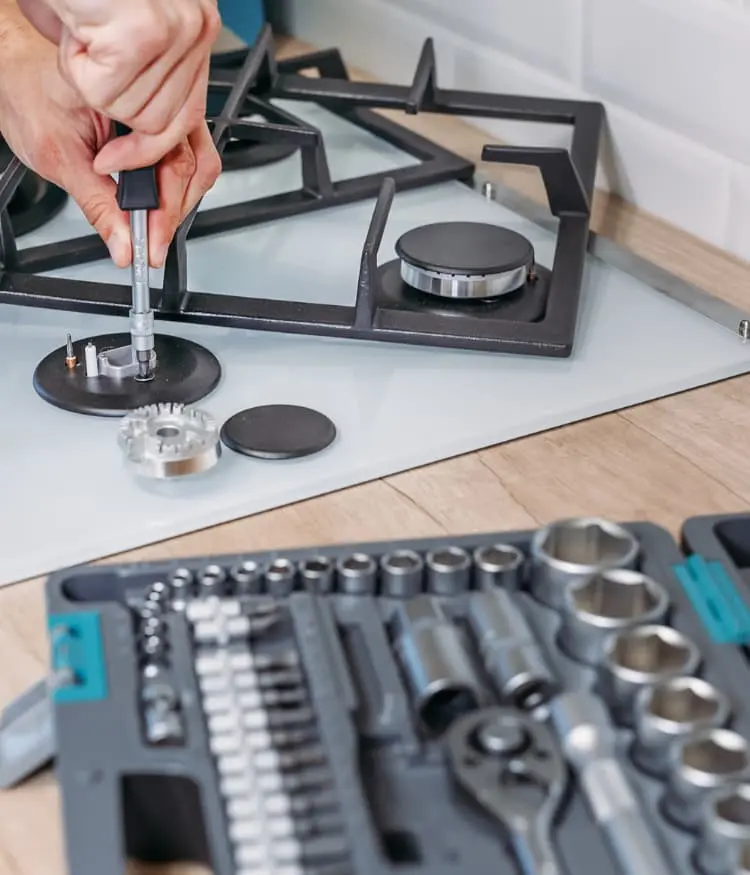 Technician repairing a gas cooktop burner in Mira Mesa