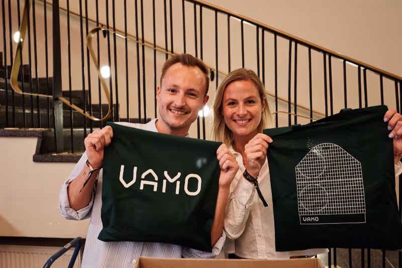 Zwei Kollegen von Vamo mit Merch Teilen. 