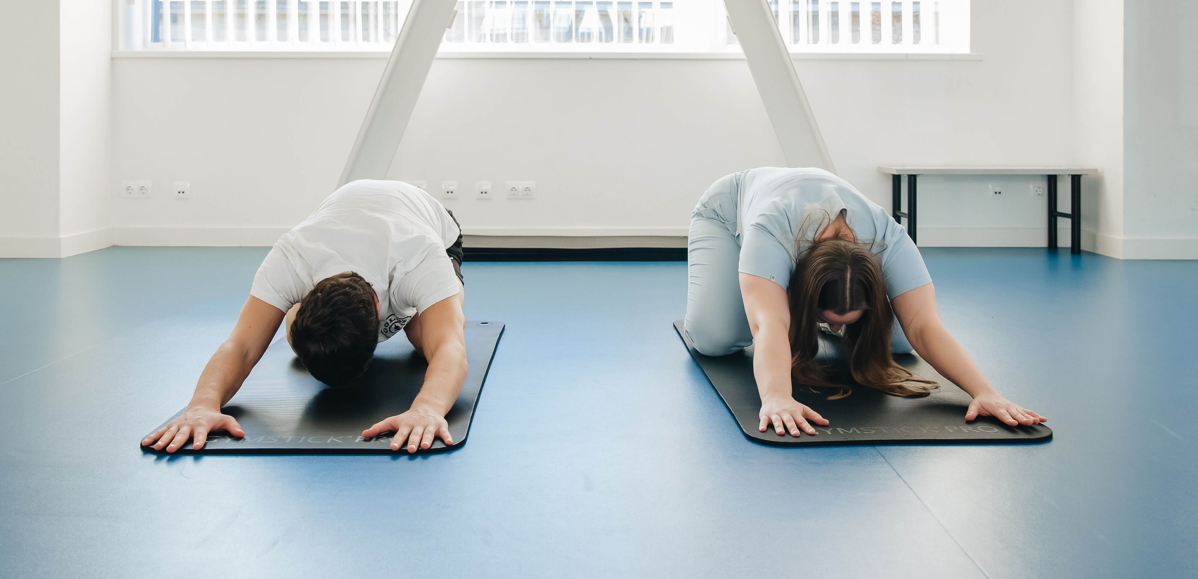 Cours de yoga à Hélioparc, tapis mauves devant une grande baie vitrée