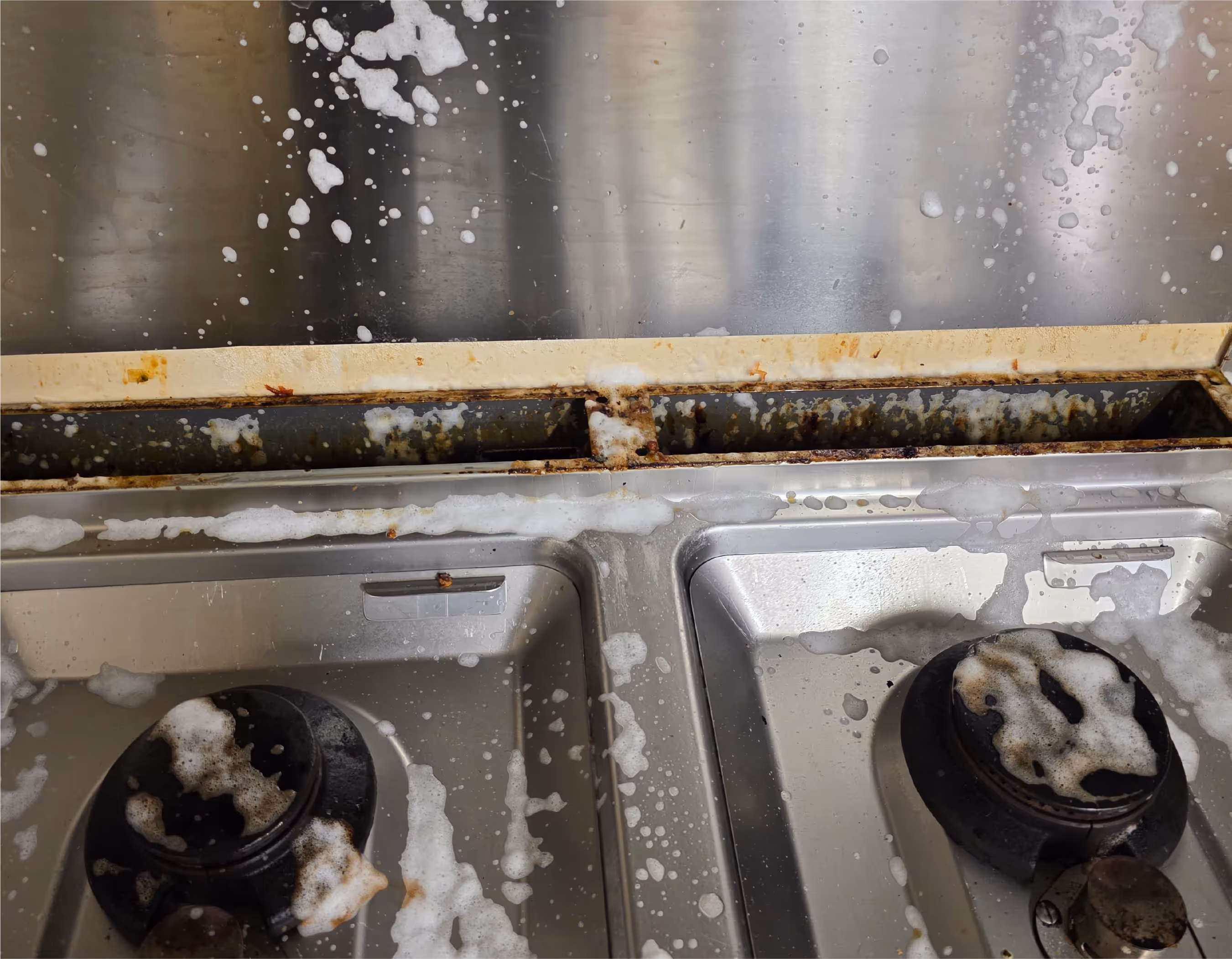 Großküche vor der Grundreinigung – stark verschmutzte Arbeitsflächen und Bodenbereiche