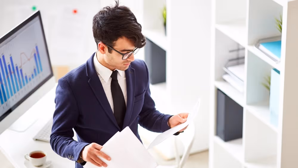Business professional reviewing documents in office Beyond Border