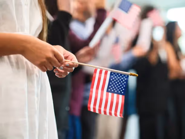 Person holding small American flag indoors Beyond Border