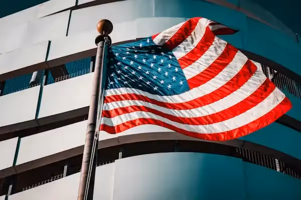 American flag waving in front of modern building Beyond Border