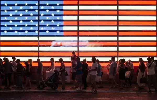 People walking past large American flag display Beyond Border