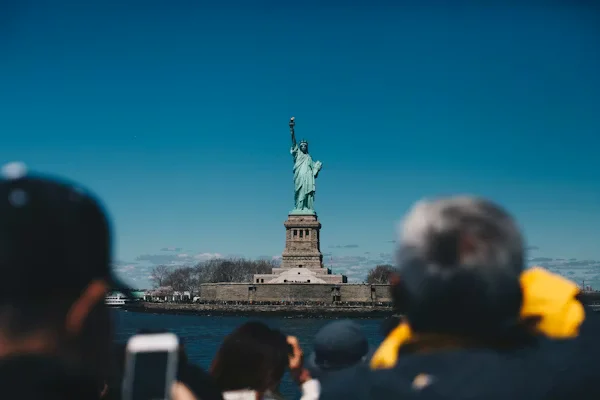 Statue of Liberty viewed by tourists from waterfront Beyond Border