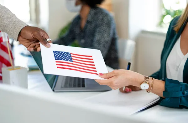 Person handing over paper with American flag Beyond Border