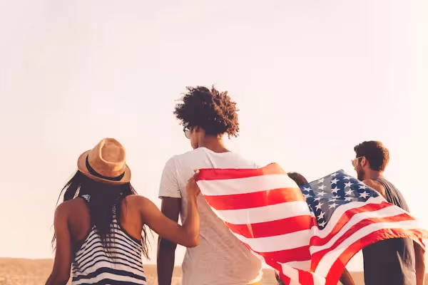 Group of people walking together holding the U.S. flag Beyond Border