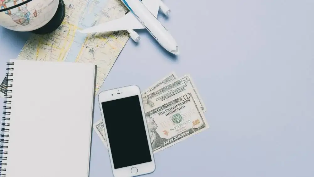 Travel planning items with map, phone, and cash Beyond Border