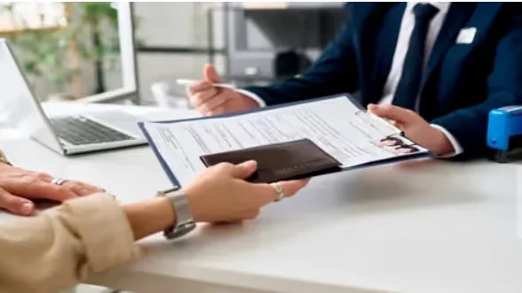 Passport and documents being exchanged during a visa consultation. Beyond Border.