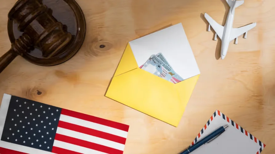 Visa in envelope with U.S. flag, gavel, and airplane model. Beyond Border.