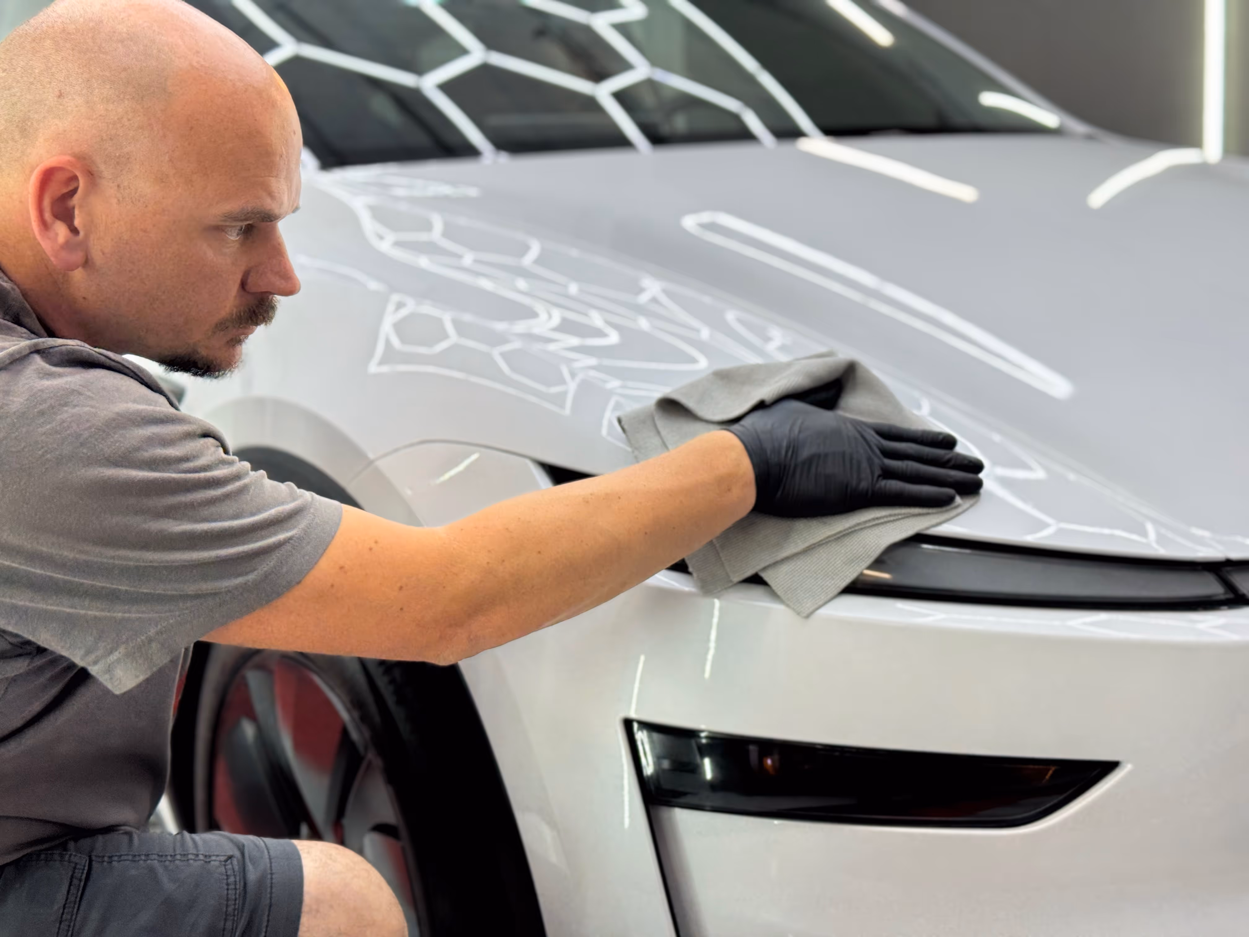 Wayne wiping down a car after the installation of paint protection film (PPF)