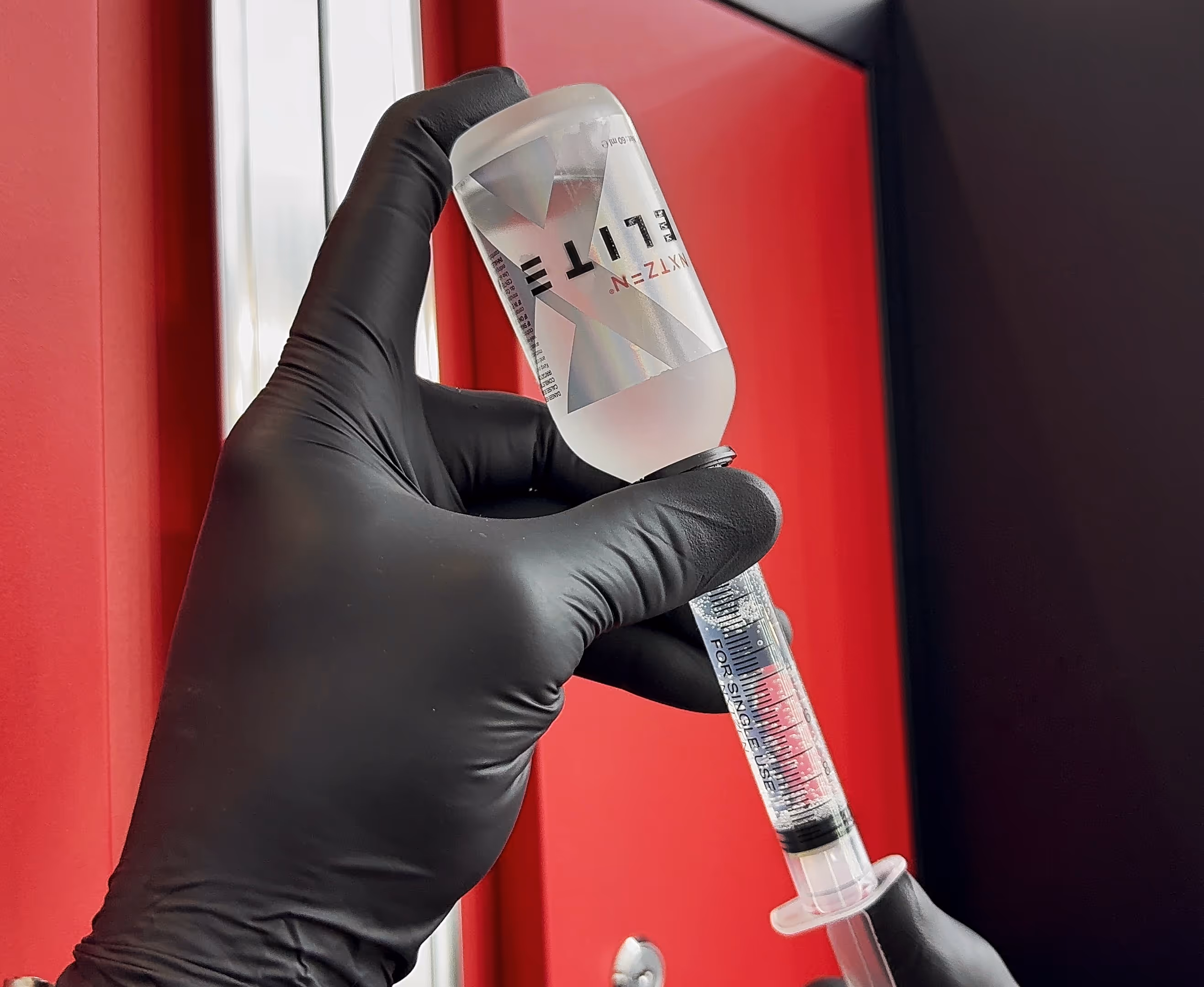 Chattanooga Auto Film Pros filling a syringe of Elite ceramic solution, their provider for Ceramic Coatings