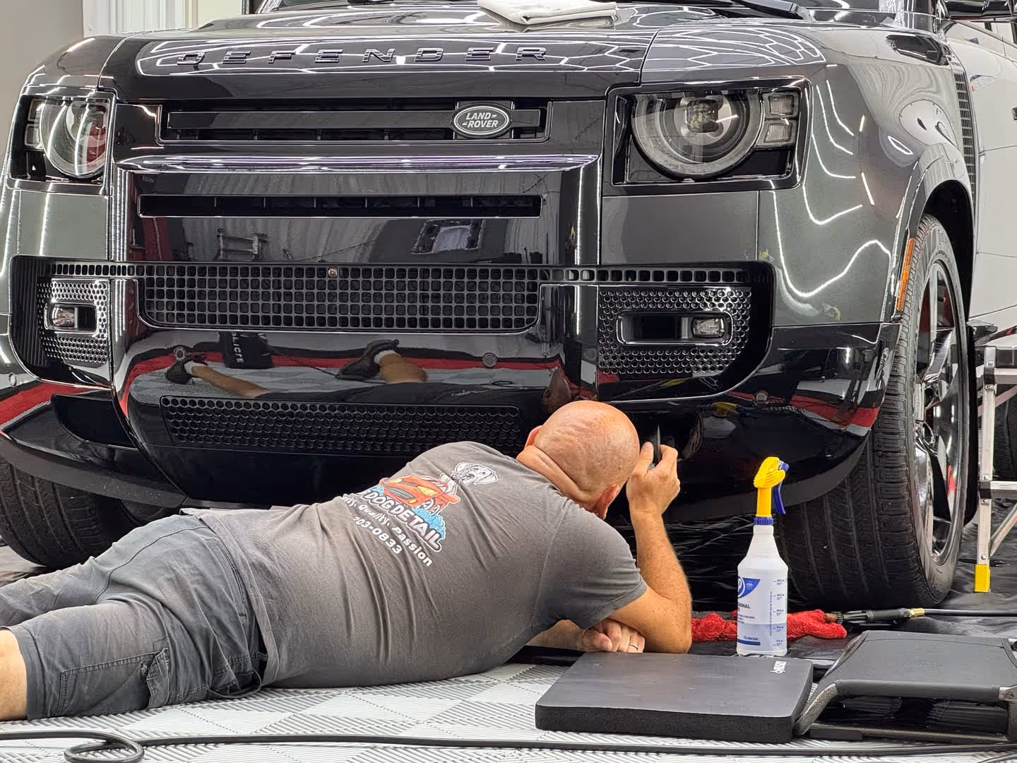 Wayne applying paint protection film to the bumper of a car in his Chattanooga auto film shop