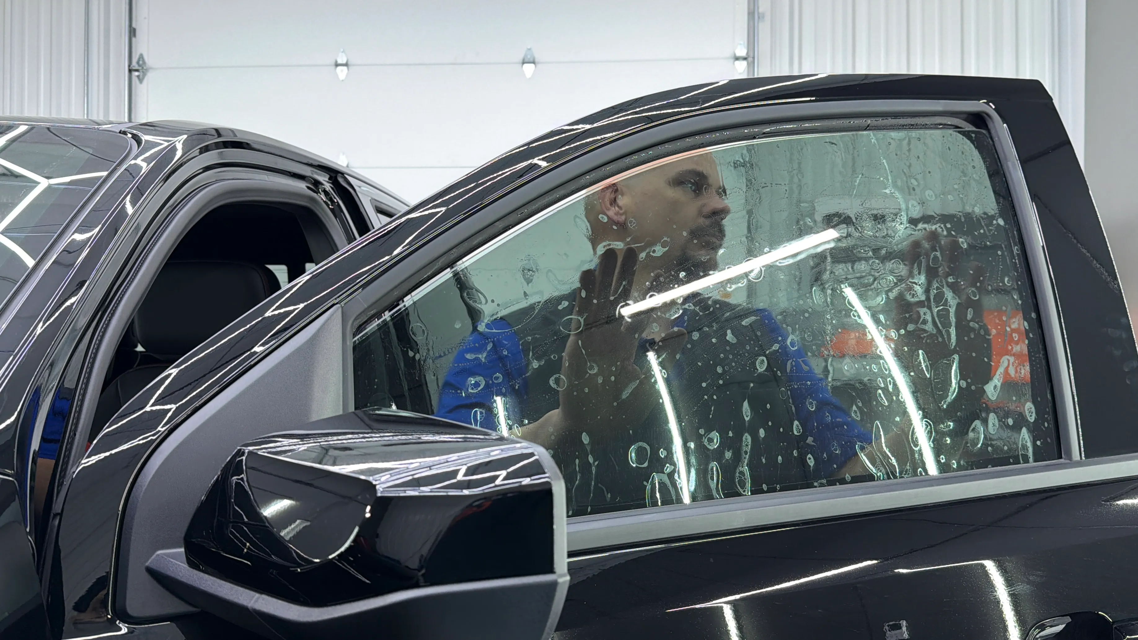 Chattanooga Auto Film Pros installer applying window tint to a truck's front door window