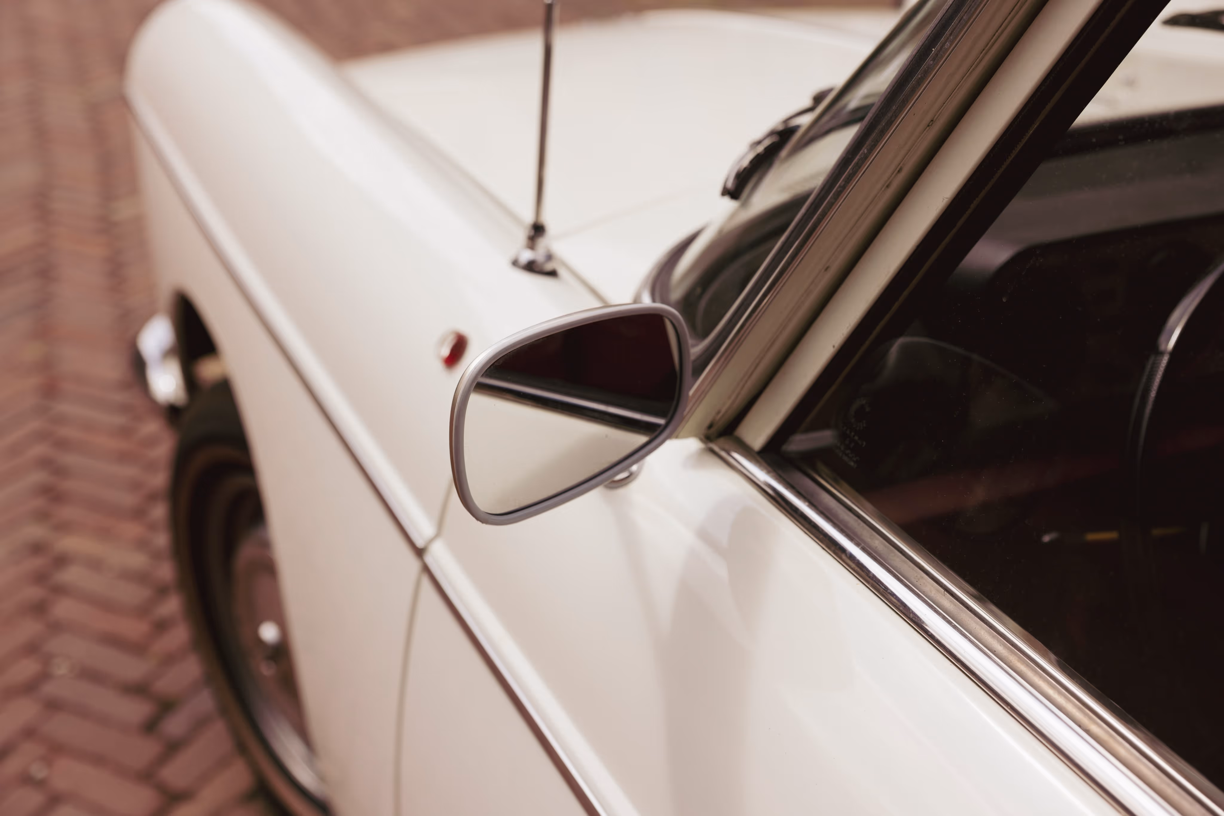 Borgo klassieke trouwauto met vintage zijspiegel op bakstenen ondergrond