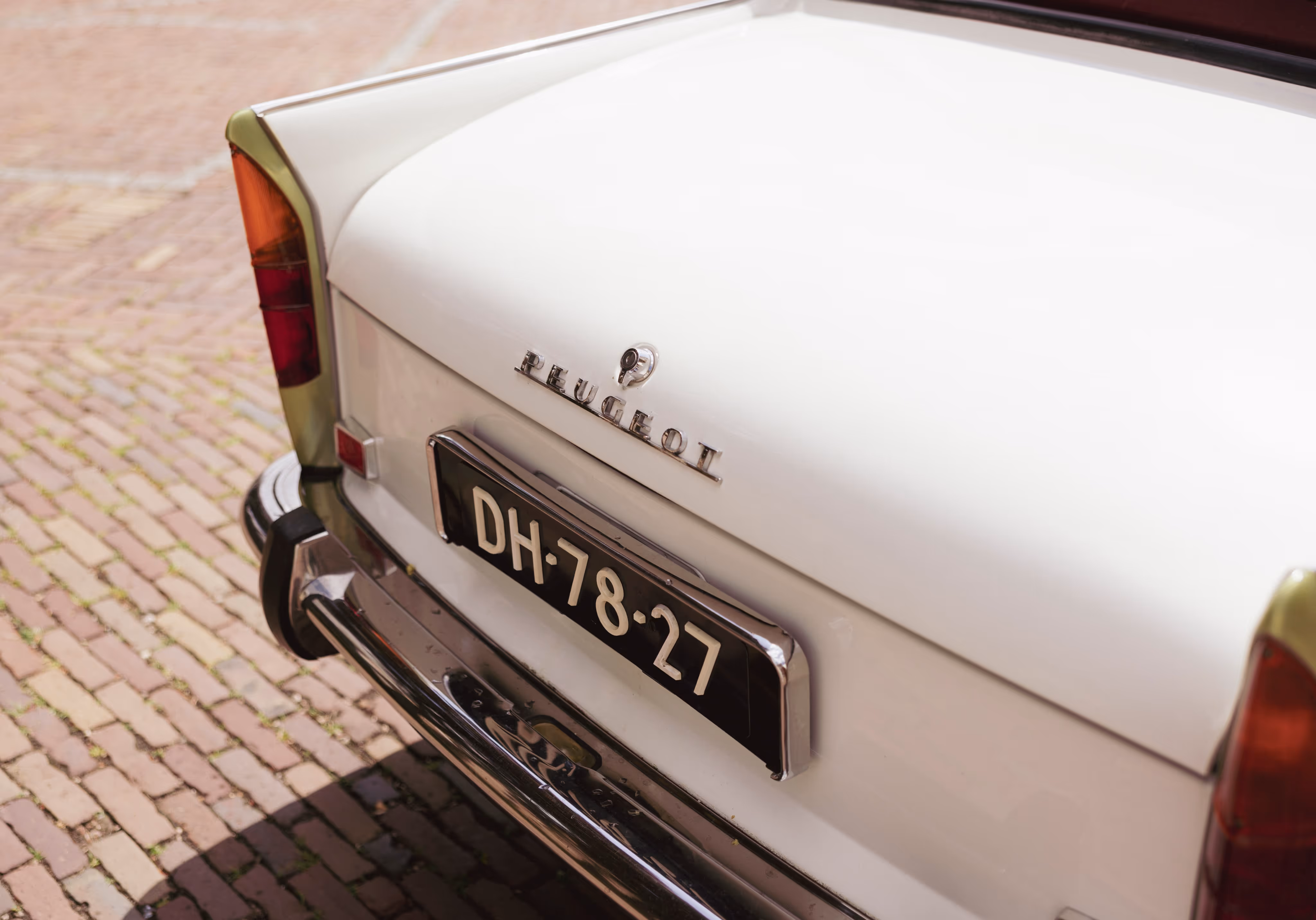 Klassieke borgo Peugeot trouwauto met vintage kentekenplaat op bestrating
