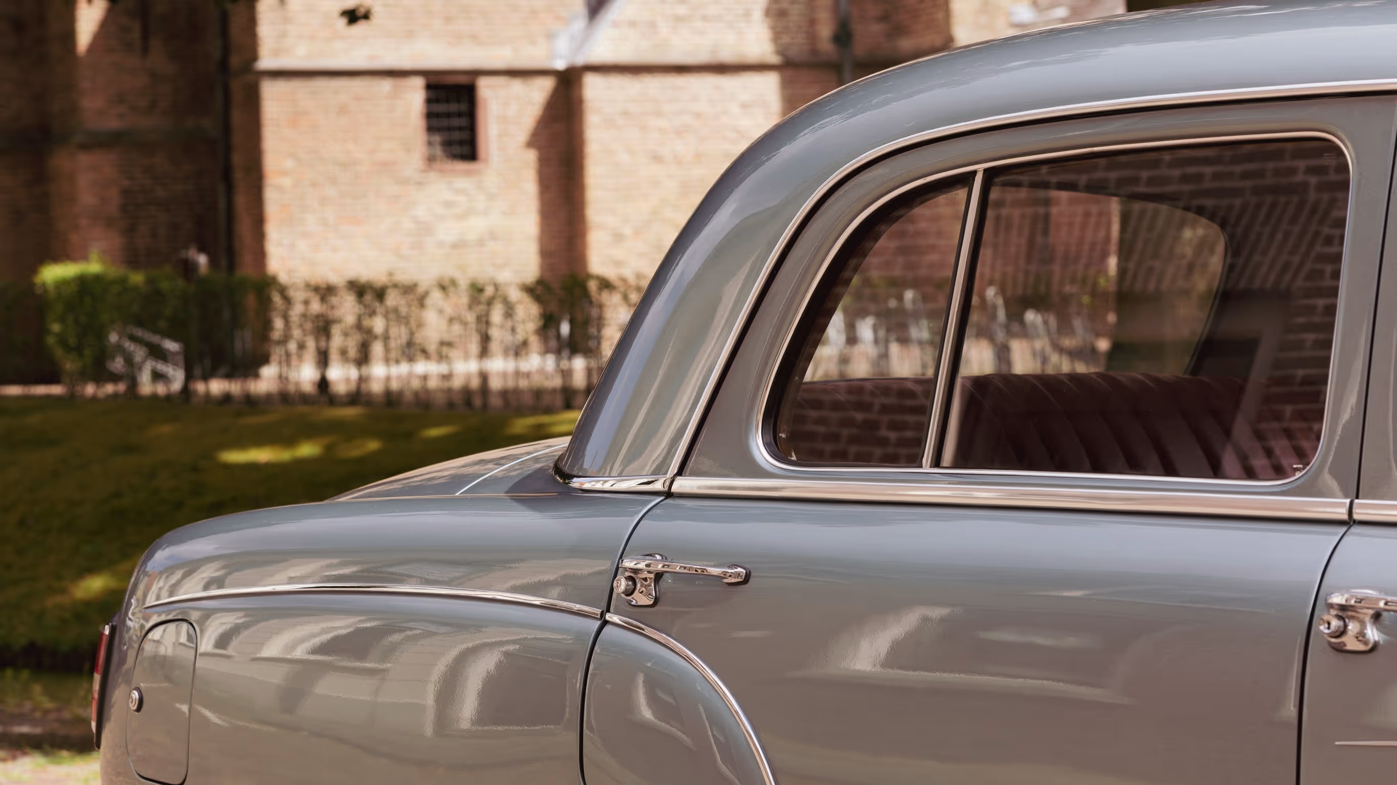 Klassieke borgo trouwauto met glanzende zilveren carrosserie voor historisch gebouw