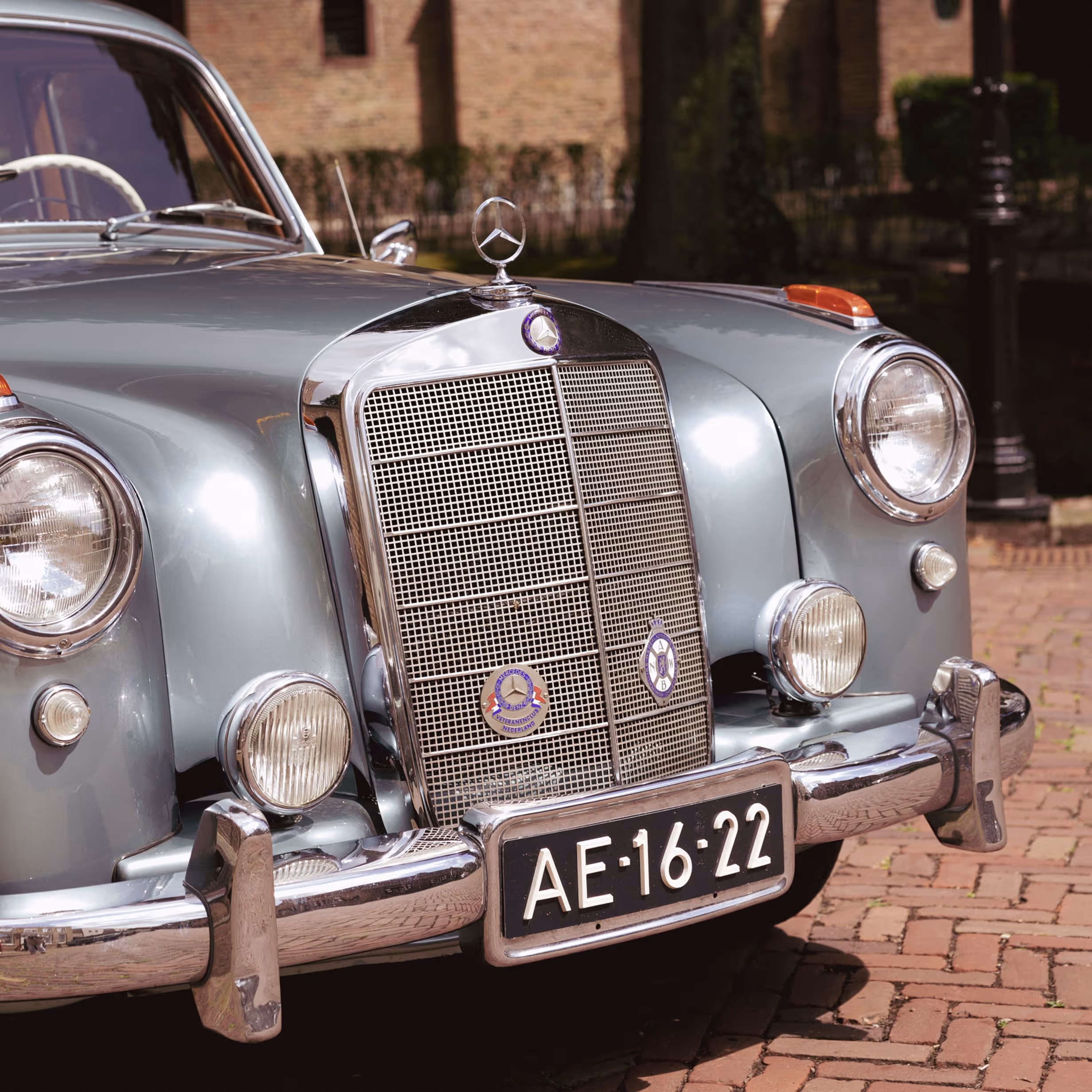 Klassieke borgo Mercedes trouwauto met vintage details op bakstenen pad
