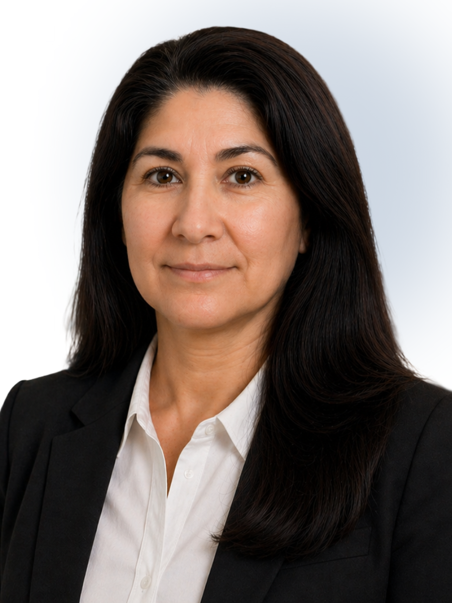 Professional woman with long dark hair wearing a white shirt and black blazer against a light background.