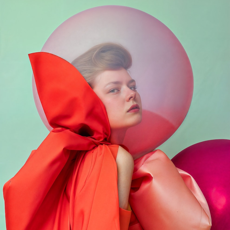 A woman in a red dress with balloons.