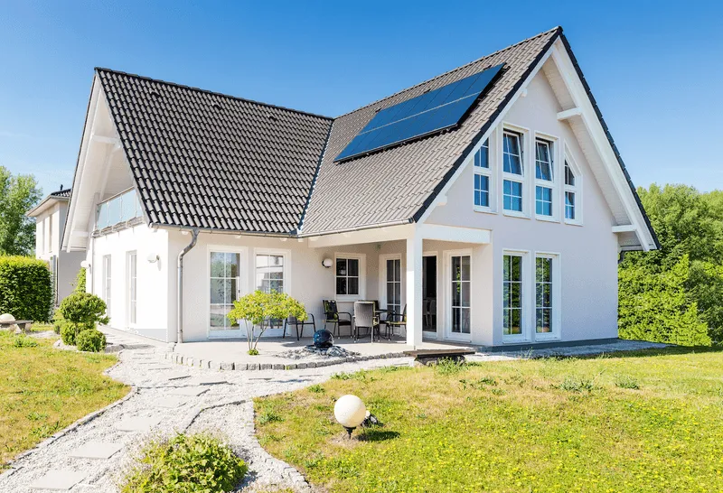 Einfamilienhaus mit kleinem Garten und Solarfeldern auf dem Dach