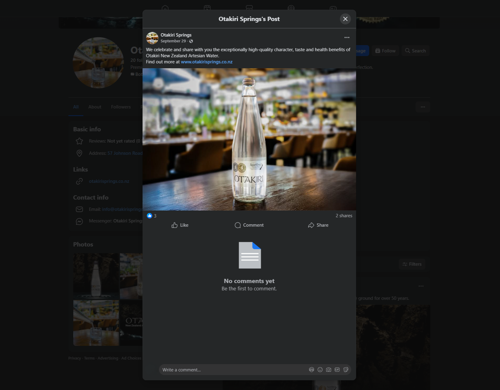 Clear glass bottle of Otakiri sparkling artesian water on a wooden table with a blurred restaurant background.