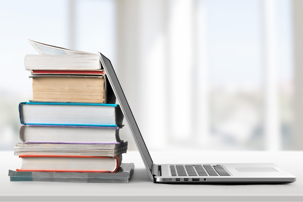 stack of books and a laptop - looking for accounting, bookkeeping and tax resources
