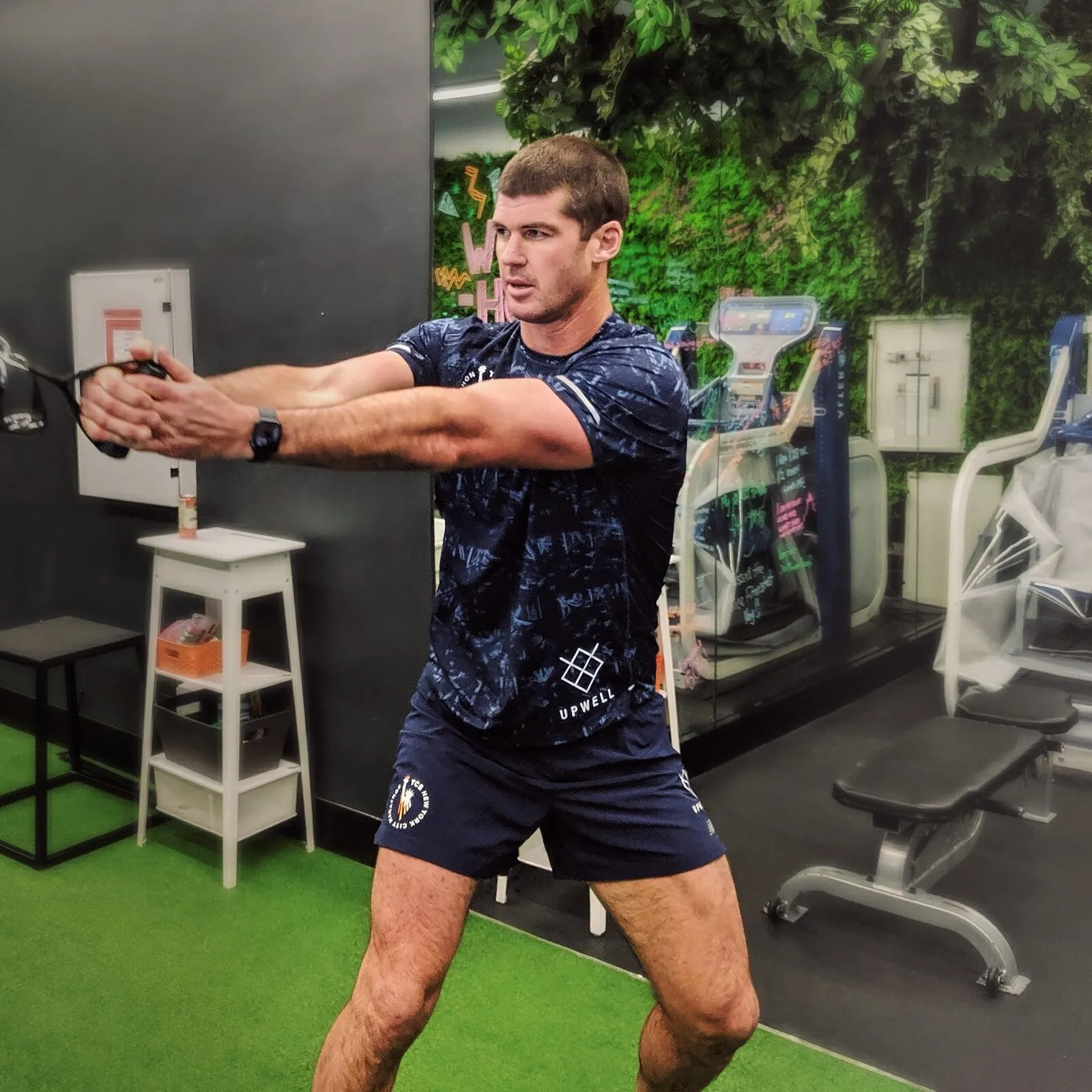 Jesse Brown performing an exercise physiology assessment with woodchop movement at Upwell Health