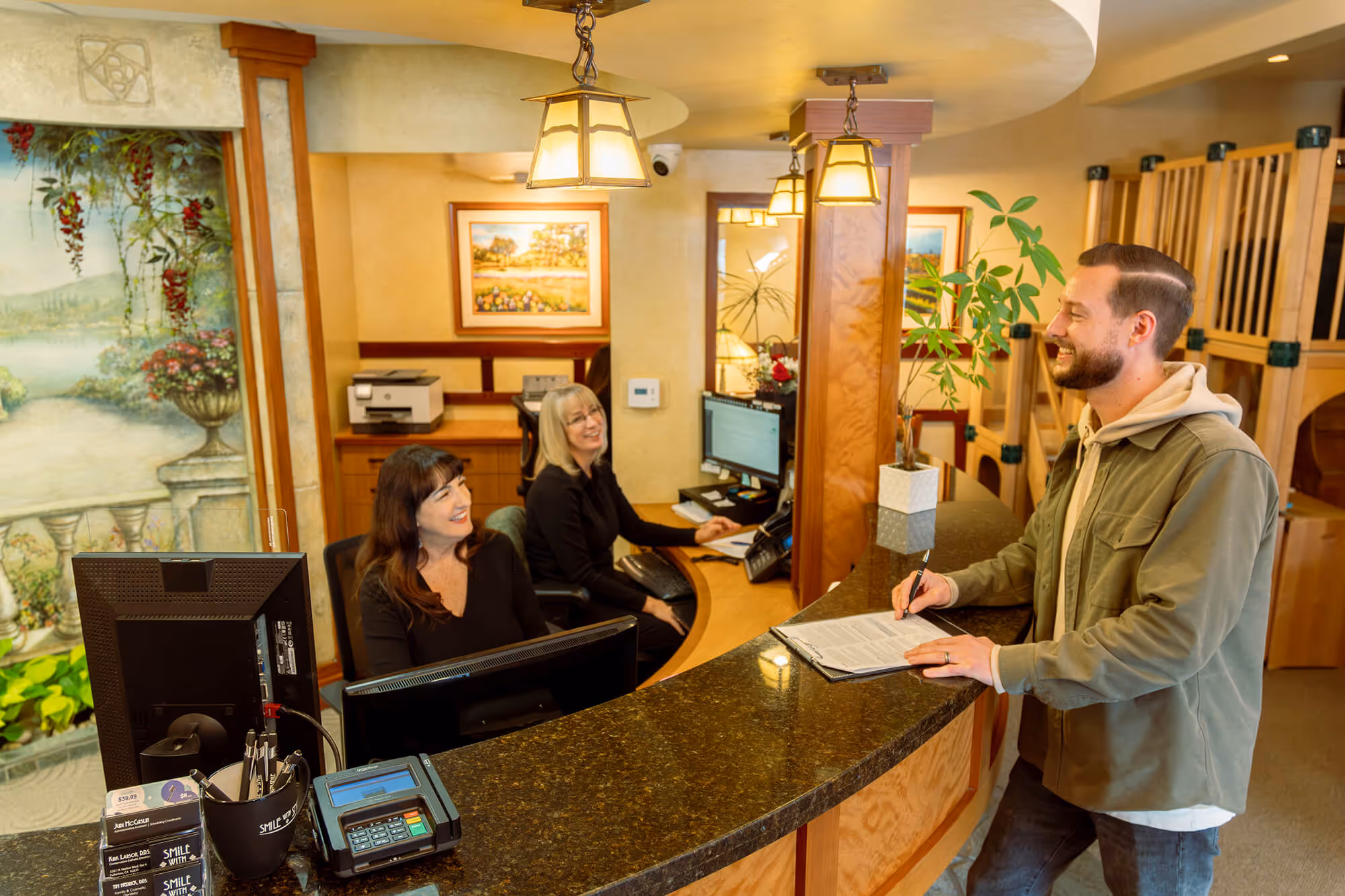 A man standing in front of a reception desk.