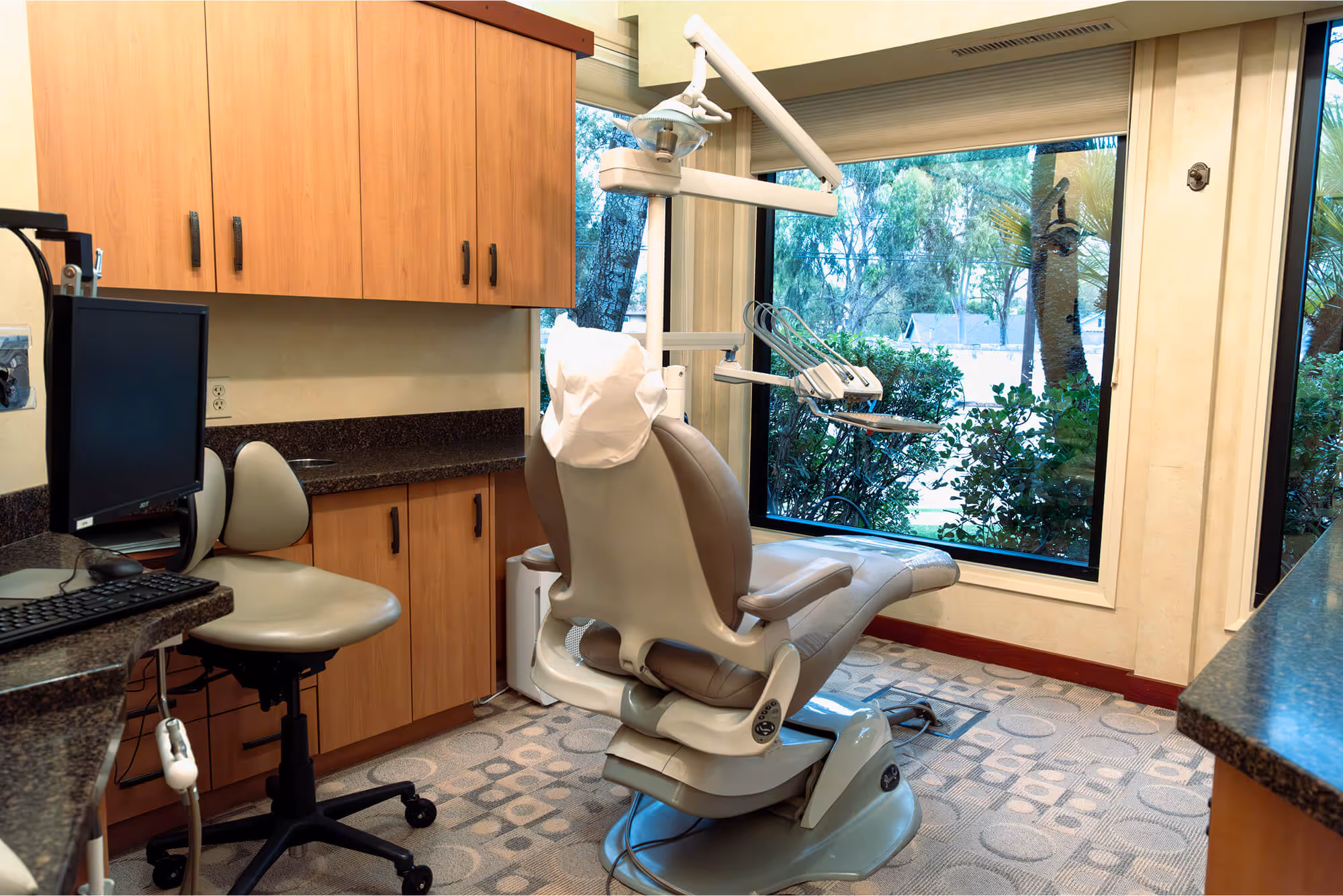 A dentist chair in a room with a window.