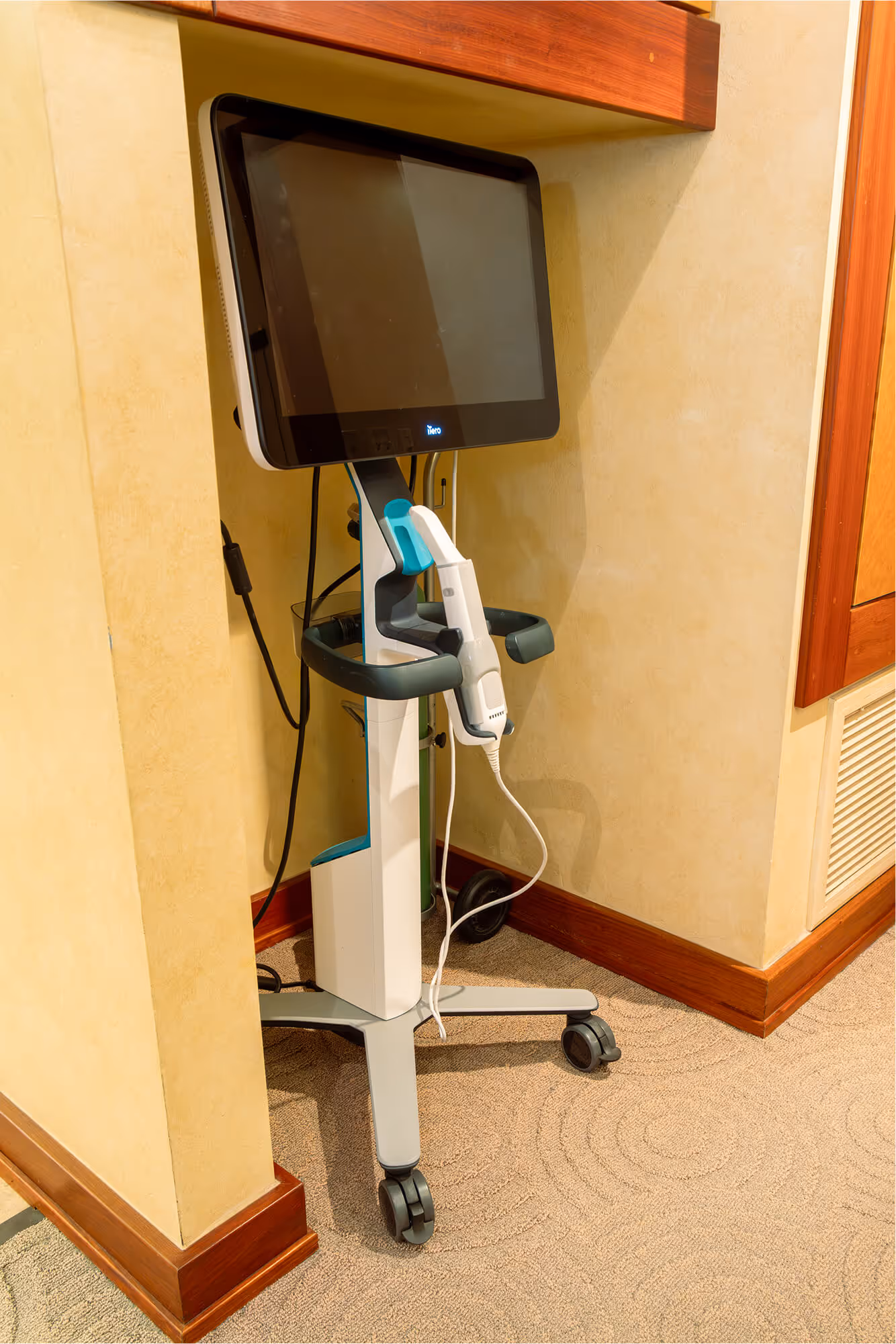 A computer monitor sitting on top of a white cart.