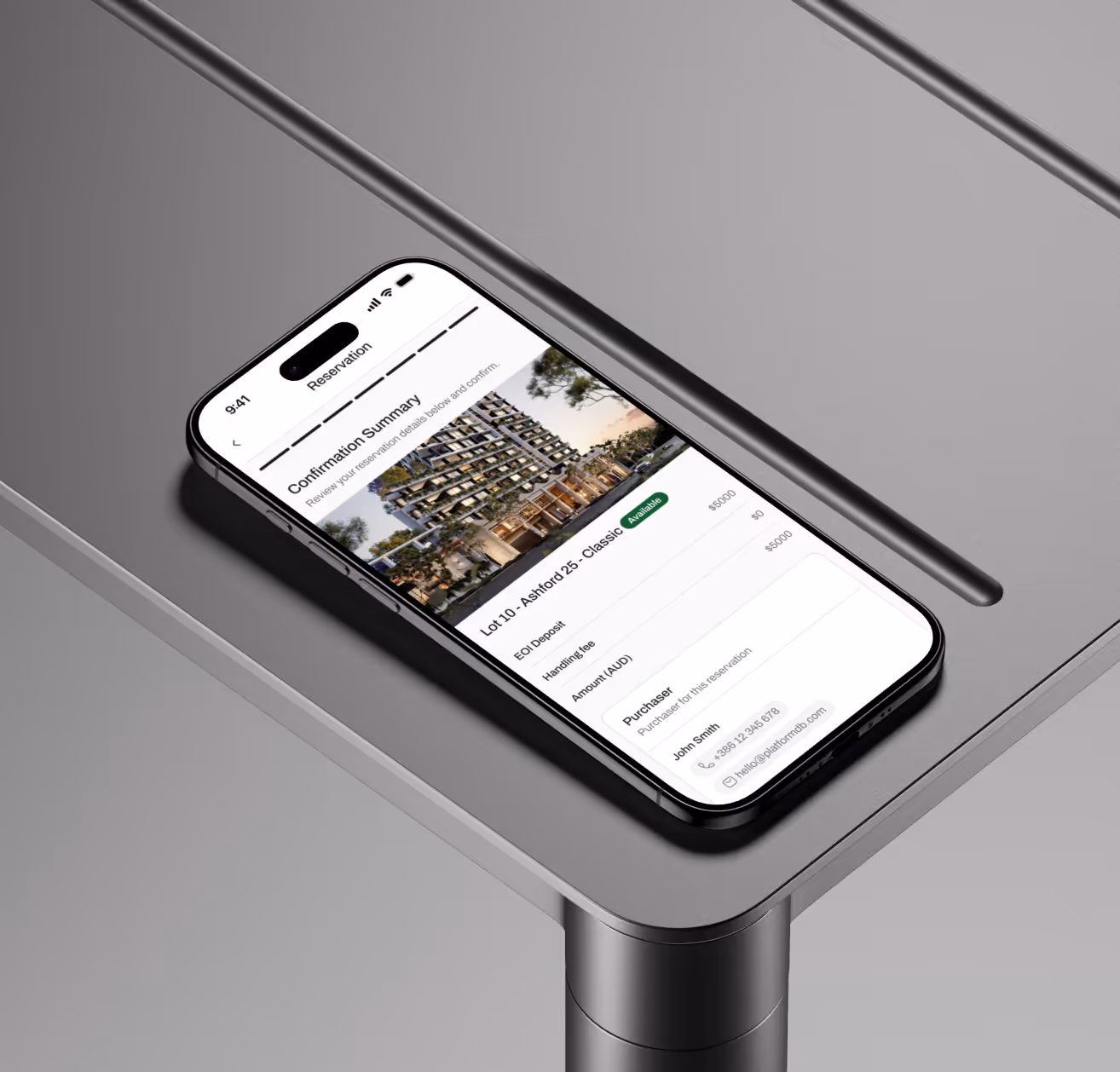 Smartphone on gray table showing a reservation confirmation summary for a property listing.