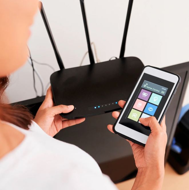 Woman configuring Wi-Fi system integration with smartphone for smart home automation and irrigation control.