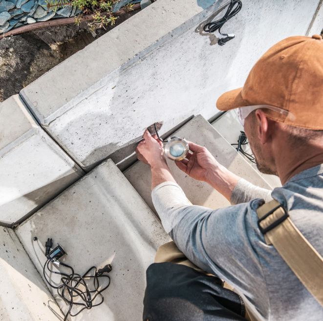 Specialist wiring low-voltage outdoor lighting system for pathway and garden safety upgrades.